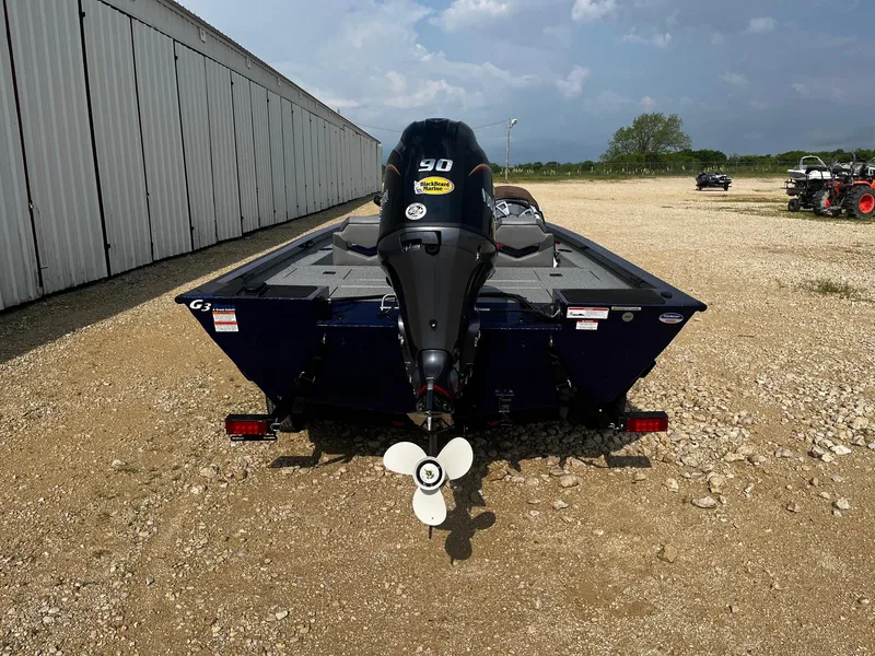 Slide: The Image of 2025 G3 Sportsman 1710 boat with 90 HP motor, parked on gravel near a warehouse. - 6