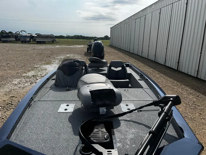 Slide: The Image of 2025 G3 Sportsman 1710 boat parked on gravel near a large building. - 7