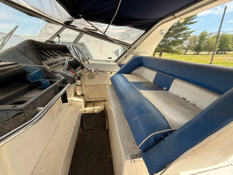 Slide: The Image of 1986 Cruisers 337 boat interior with blue seating and steering area. - 11