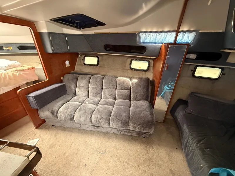 Slide: The Image of Interior of 1986 Cruisers 337 yacht with plush seating and cozy cabin space. - 13