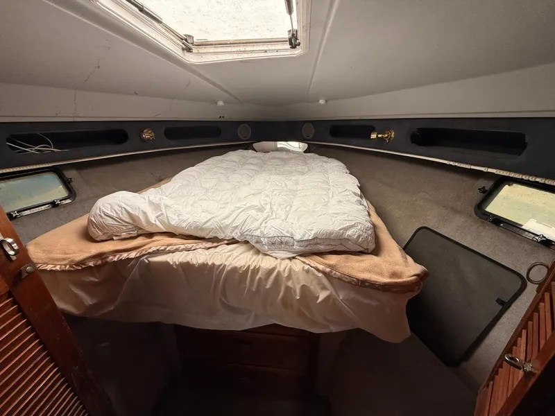Slide: The Image of Cozy cabin interior of 1986 Cruisers 337 boat with bed and portholes. - 15