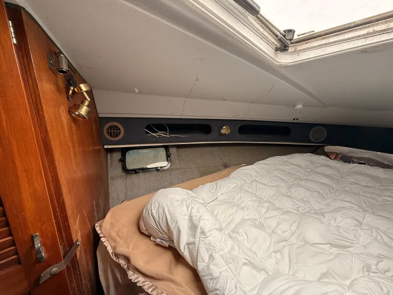 Slide: The Image of Cozy cabin interior of 1986 Cruisers 337 boat with bed and wooden accents. - 16