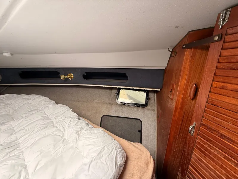 Slide: The Image of Interior cabin of a 1986 Cruisers 337 boat with bedding and wooden cabinetry. - 17