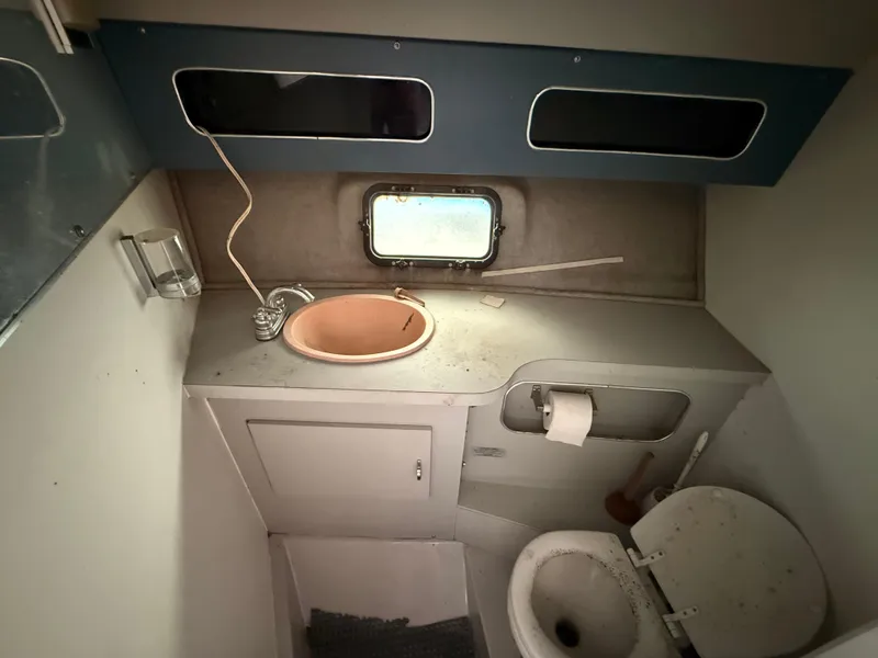 Slide: The Image of 1986 Cruisers 337 boat bathroom with sink, toilet, and small window. - 18