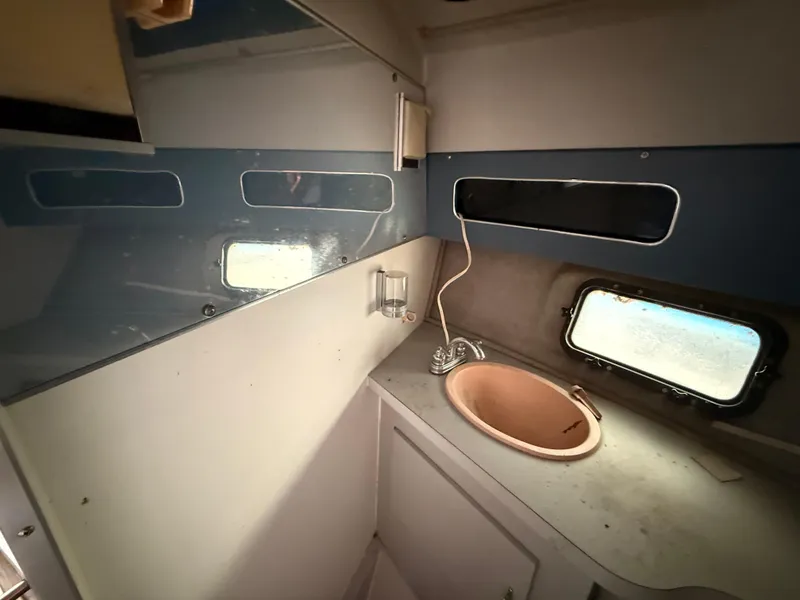 Slide: The Image of 1986 Cruisers 337 boat bathroom with sink, mirror, and porthole window. - 19