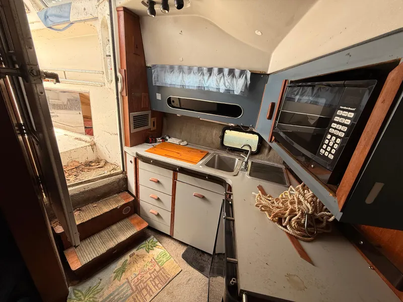 Slide: The Image of Interior of a 1986 Cruisers 337 boat kitchen with sink, microwave, and storage. - 20