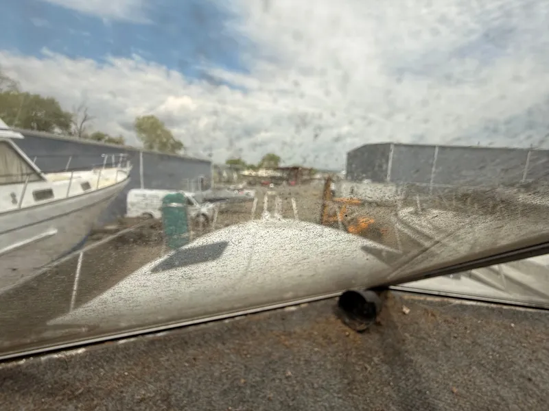 Slide: The Image of 1986 Cruisers 337 boat view through a dusty window, docked in a marina. - 22