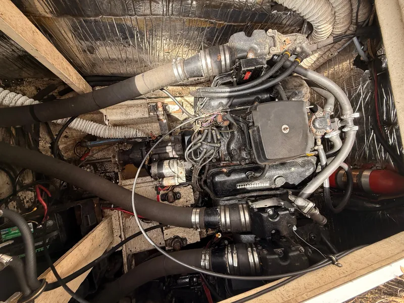 Slide: The Image of 1986 Cruisers 337 engine compartment with visible hoses and wiring. - 23
