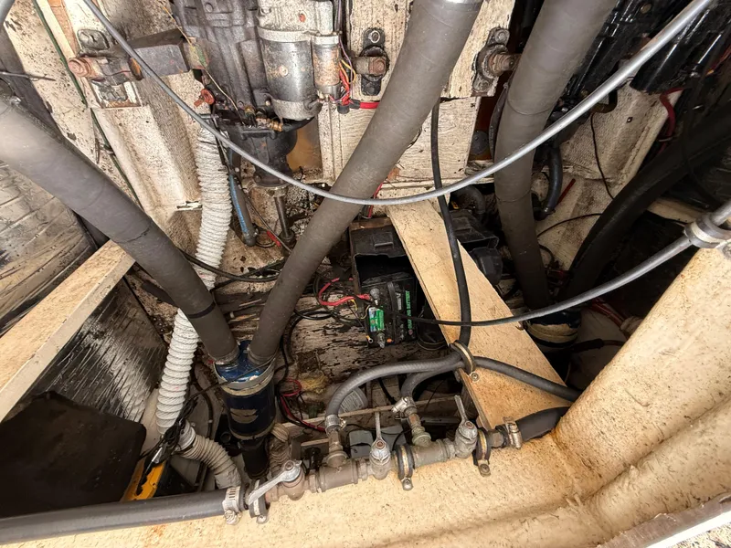 Slide: The Image of Engine compartment of a 1986 Cruisers 337 boat, showing hoses and mechanical components. - 24