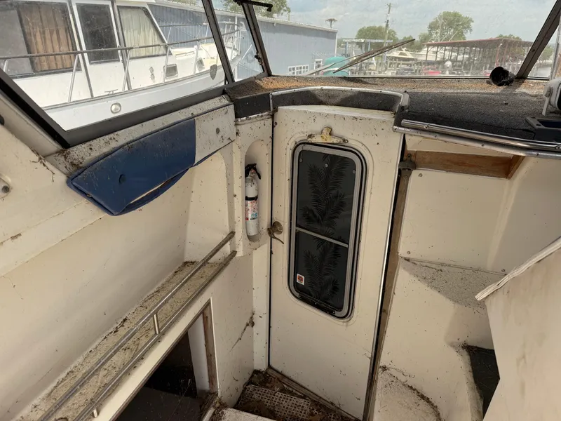 Slide: The Image of Interior of a 1986 Cruisers 337 boat, showing a weathered cabin entrance. - 5