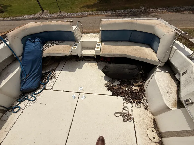 Slide: The Image of 1986 Cruisers 337 boat interior with worn seating and ropes on deck. - 6