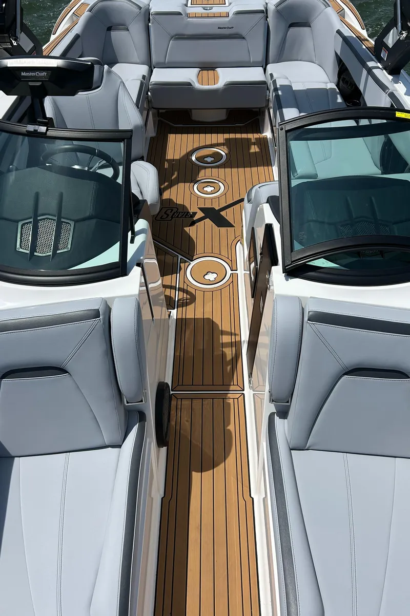 Slide: The Image of 2024 MasterCraft XStar S boat interior with sleek seating and wooden flooring. - 12