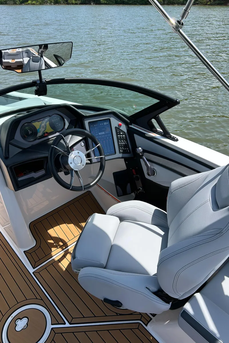 Slide: The Image of 2024 MasterCraft XStar S boat interior with modern dashboard and steering wheel on a sunny day. - 4