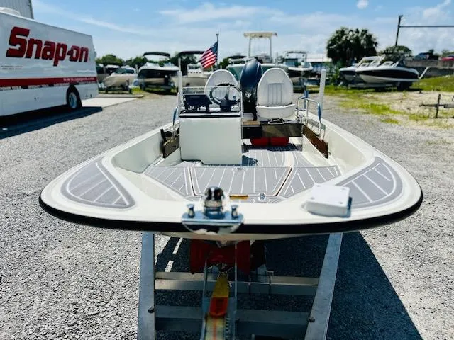 Slide: The Image of 1986 Boston Whaler 150 Sport boat on trailer, surrounded by other boats and a Snap-on truck. - 11