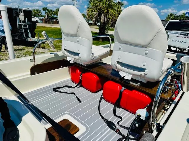 Slide: The Image of 1986 Boston Whaler 150 Sport interior with white seats and red fuel tanks. - 18