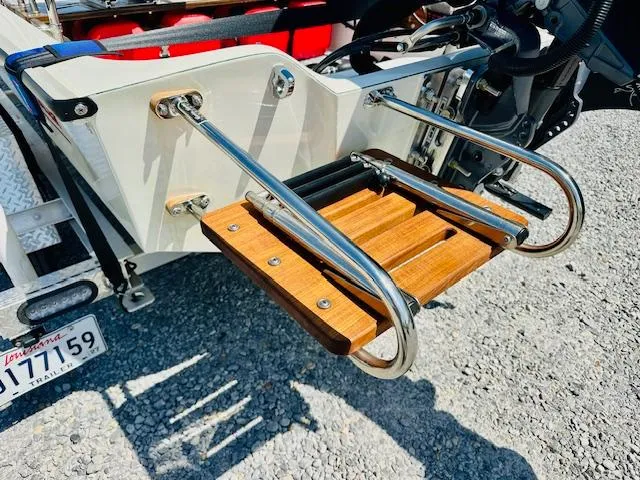 Slide: The Image of Boston Whaler 150 Sport 1986 boat ladder with stainless steel and wood design. - 23