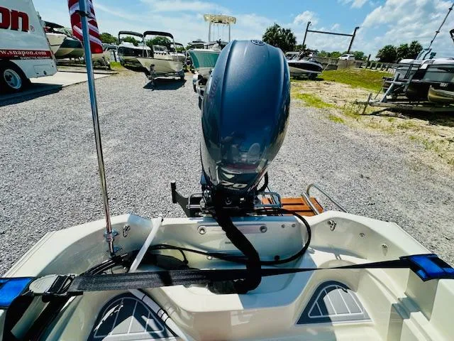 Slide: The Image of 1986 Boston Whaler 150 Sport boat with outboard motor, parked on gravel lot. - 31