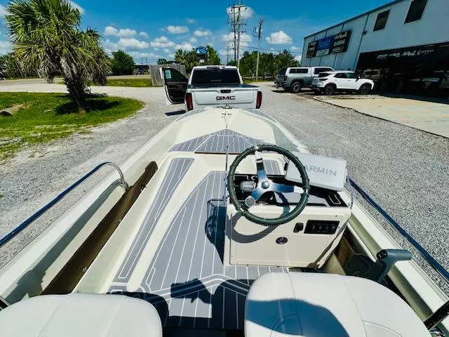 Slide: The Image of 1986 Boston Whaler 150 Sport boat interior with steering wheel, parked near GMC truck. - 33