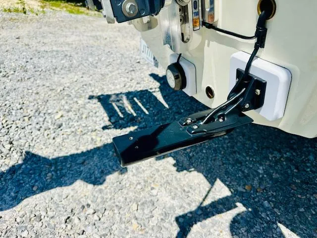 Slide: The Image of 1986 Boston Whaler 150 Sport boat transom with mounted equipment on gravel surface. - 35