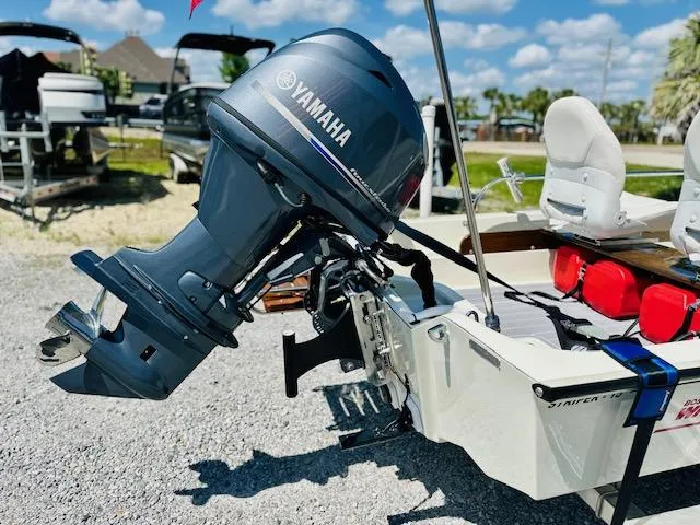 Slide: The Image of 1986 Boston Whaler 150 Sport with Yamaha outboard motor, parked on gravel. - 5