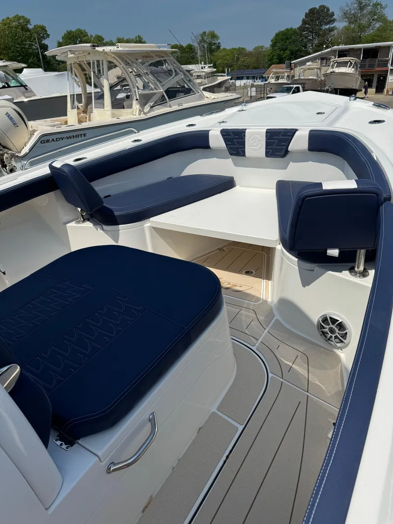 Slide: The Image of 2025 Parker 2600 Center Console boat with blue and white seating, docked in a marina. - 7
