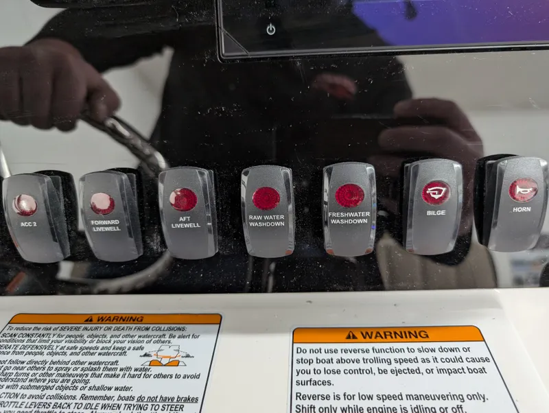 Slide: The Image of Control panel of 2024 Yamaha Boats 255 FSH Sport H with labeled switches and warnings. - 12