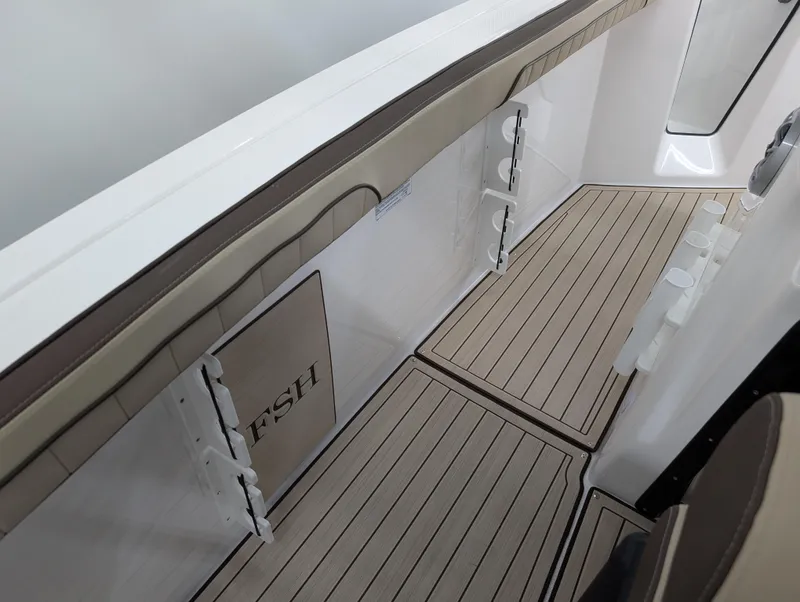 Slide: The Image of 2024 Yamaha Boats 255 FSH Sport H interior with sleek deck design and storage features. - 15