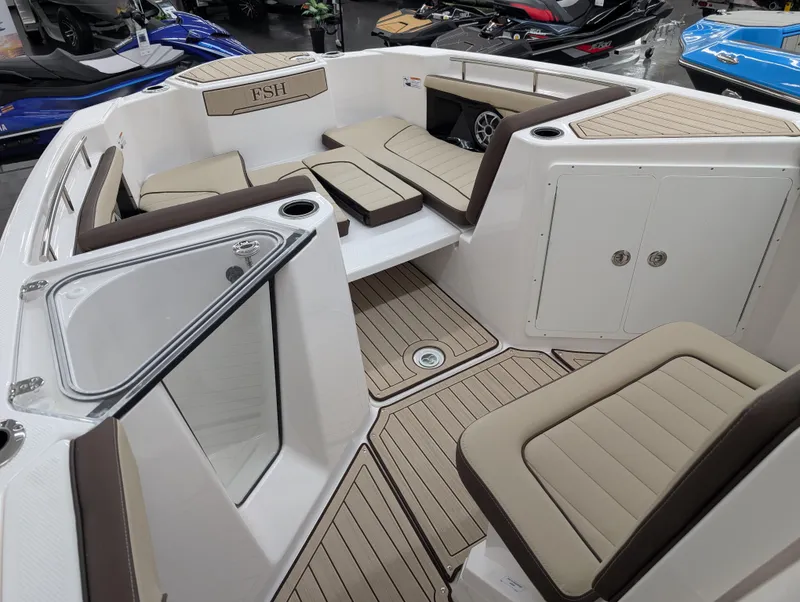 Slide: The Image of 2024 Yamaha Boats 255 FSH Sport H interior with beige seating and teak flooring. - 16