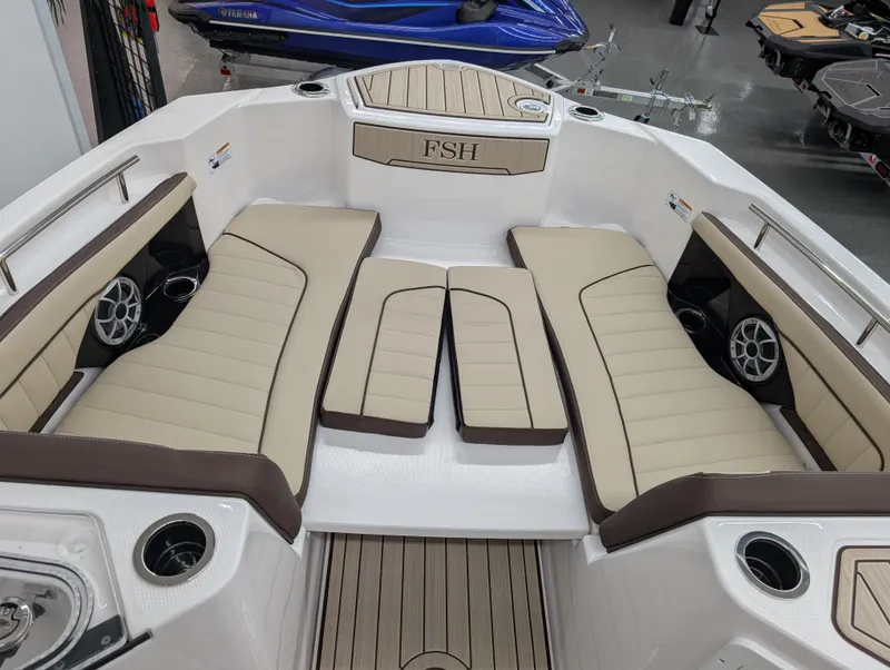 Slide: The Image of 2024 Yamaha Boats 255 FSH Sport H interior with beige seating and cup holders. - 19