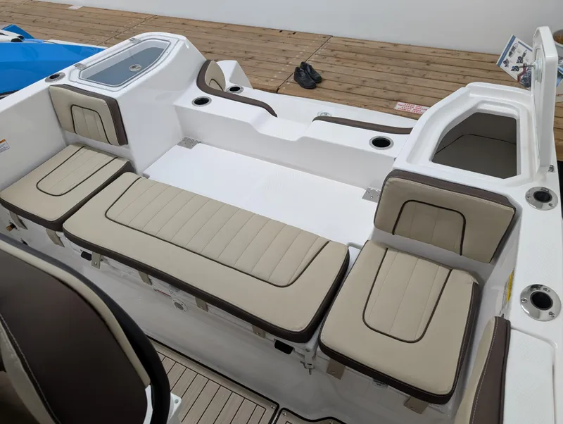 Slide: The Image of 2024 Yamaha Boats 255 FSH Sport H interior seating with beige cushions and white deck. - 22