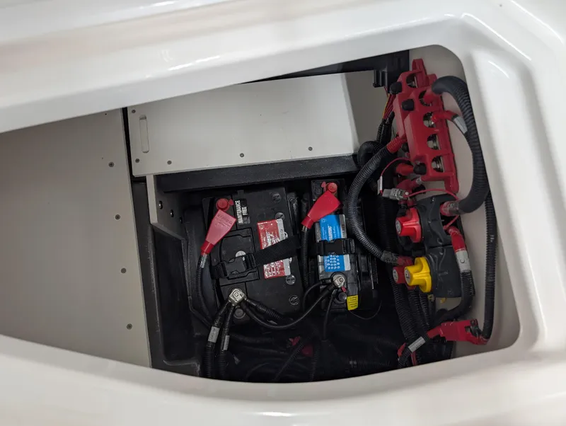 Slide: The Image of 2024 Yamaha Boats 255 FSH Sport H battery compartment with wiring and connections. - 4