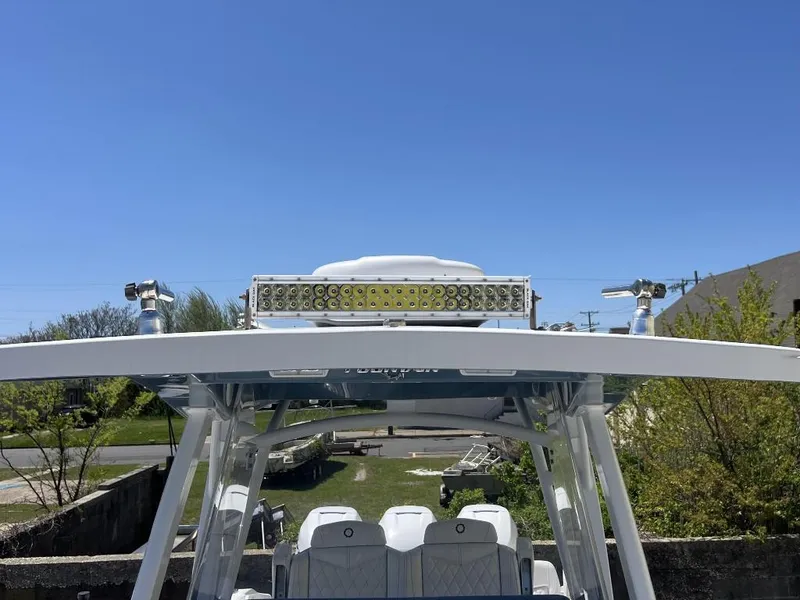 Slide: The Image of 2021 Fountain 34 CC LS boat with T-top and LED light bar, clear blue sky. - 14