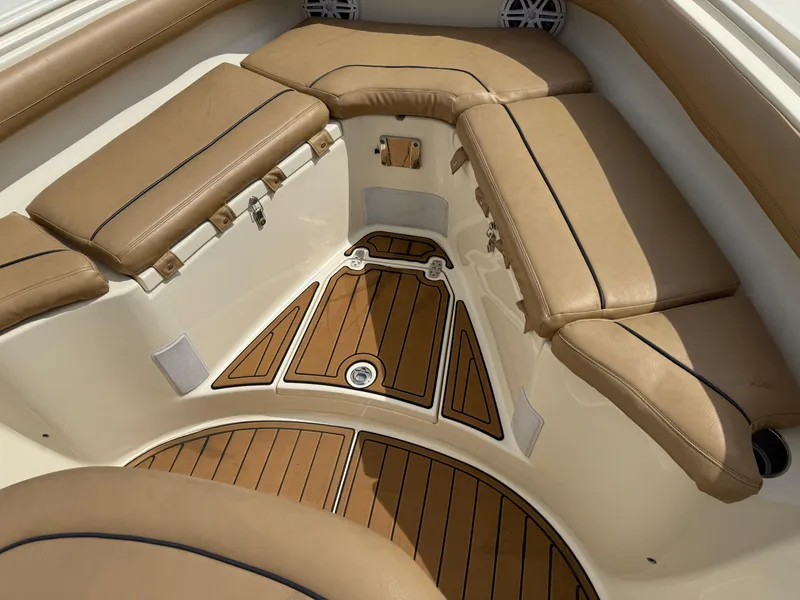 Slide: The Image of 2016 Scout 300 LXF boat interior with tan cushioned seating and teak flooring. - 13