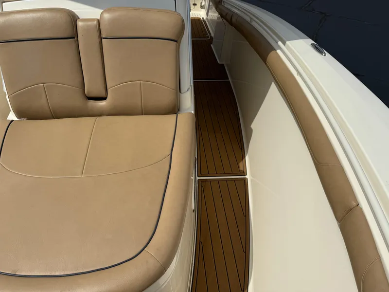 Slide: The Image of 2016 Scout 300 LXF boat interior with tan leather seating and wooden flooring. - 16