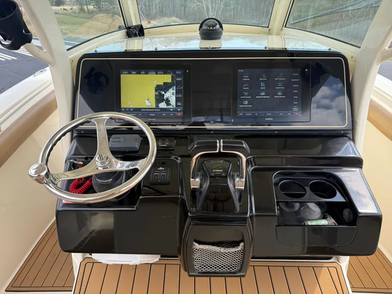Slide: The Image of 2016 Scout 300 LXF boat dashboard with dual screens and steering wheel. - 24