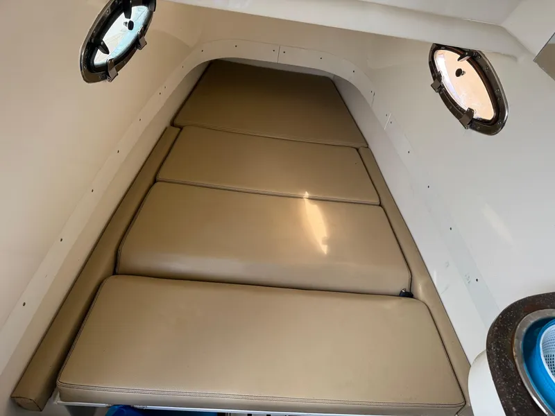 Slide: The Image of 2016 Scout 300 LXF cabin interior with beige cushions and portholes. - 27