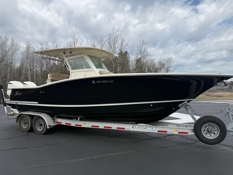 Slide: The Image of 2016 Scout 300 LXF boat on trailer, parked outdoors under cloudy sky. - 3