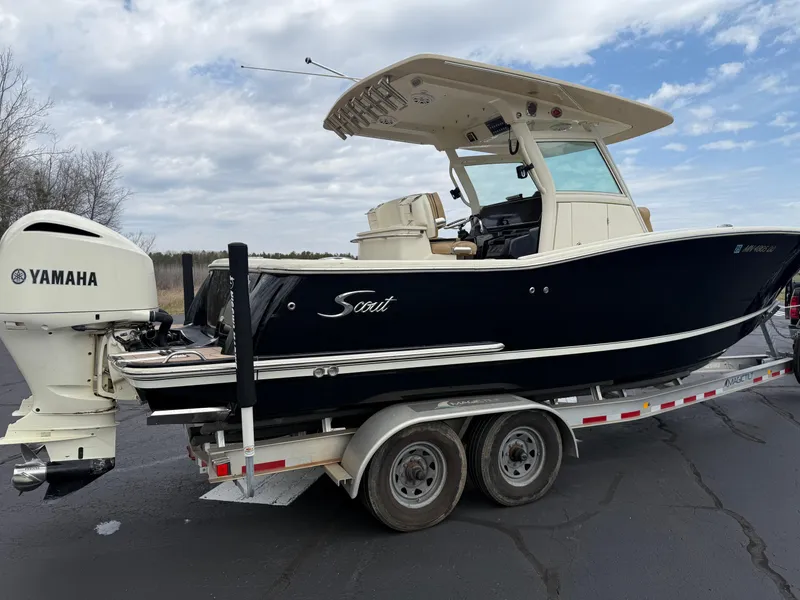 Slide: The Image of 2016 Scout 300 LXF boat on trailer with Yamaha engine, parked outdoors. - 5