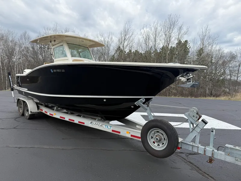 Slide: The Image of 2016 Scout 300 LXF boat on trailer, parked outdoors on a cloudy day. - 7