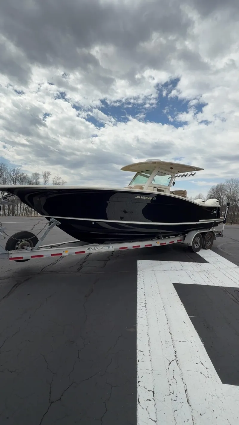 Slide: The Image of 2016 Scout 300 LXF boat on trailer under cloudy sky. - 8
