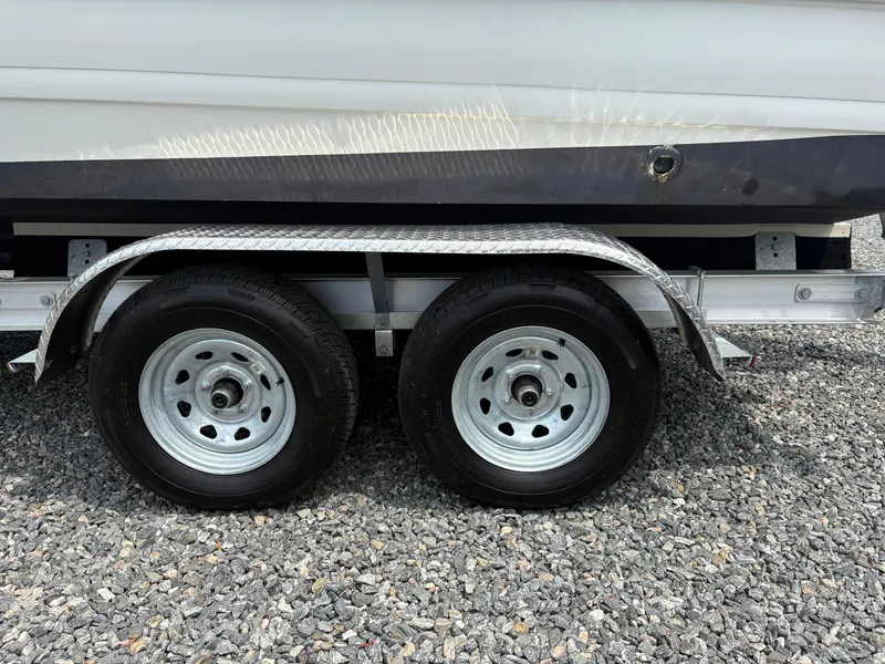 Slide: The Image of Trailer wheels of a 2021 Hurricane Center Console SS 231 OB boat on gravel. - 17