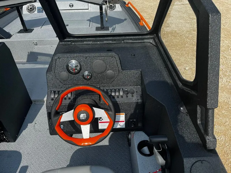 Slide: The Image of 2025 SeaArk ProCat 240 boat dashboard with orange-accented steering wheel and control panel. - 10