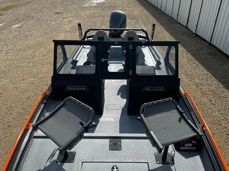Slide: The Image of 2025 SeaArk ProCat 240 boat with dual seats and windshield, parked on gravel. - 7