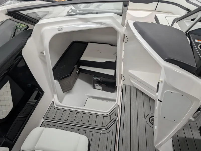 Slide: The Image of 2024 Yamaha Boats 275 SE interior cabin with seating and storage, featuring sleek design and modern finishes. - 6
