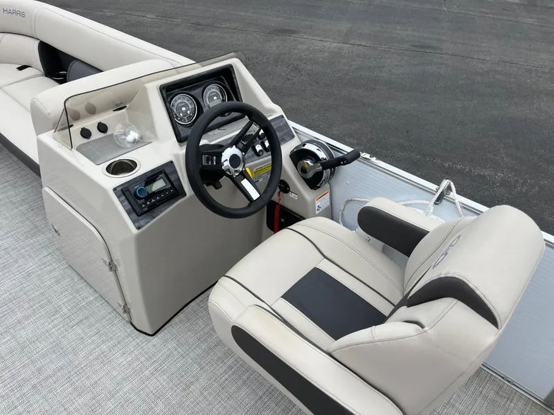 Slide: The Image of 2022 Harris Cruiser 230 boat interior with steering wheel and captain's chair. - 4