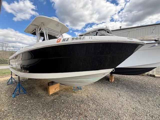 Slide: The Image of 2009 Robalo R240 Center Console boat on stands, black hull, outdoor storage. - 0