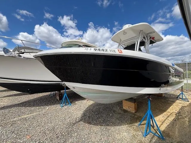 Slide: The Image of 2009 Robalo R240 Center Console boat on stands, under a partly cloudy sky. - 1