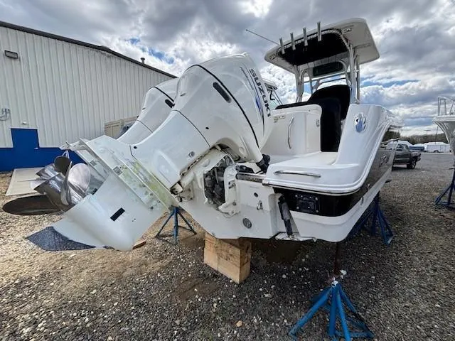 Slide: The Image of 2009 Robalo R240 Center Console boat with Suzuki outboard motor on stands. - 2