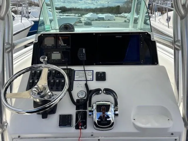 Slide: The Image of 2009 Robalo R240 Center Console helm with steering wheel and navigation controls. - 9