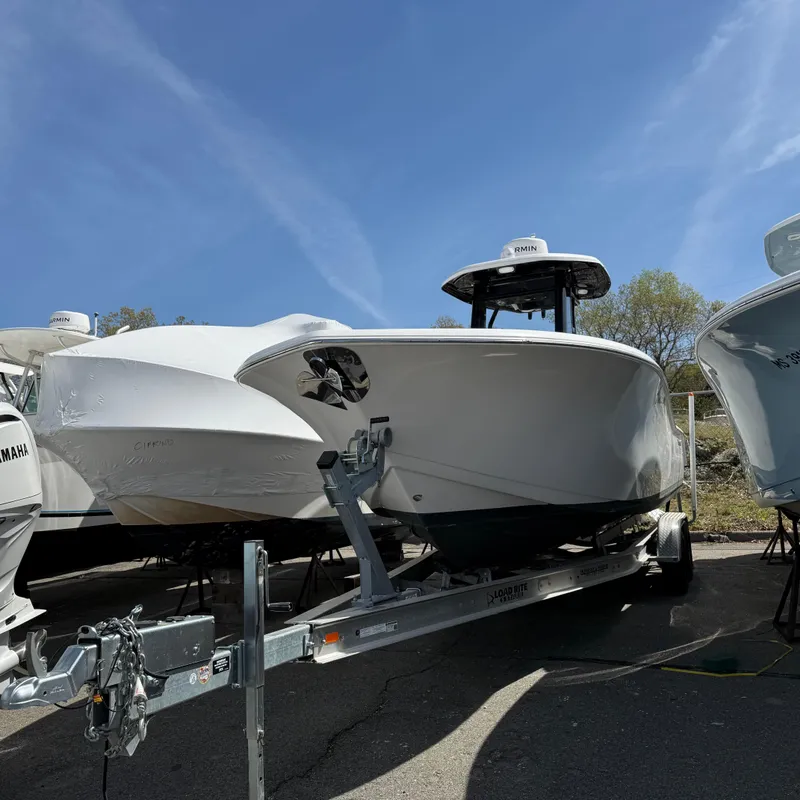 Slide: The Image of 2023 Tidewater 272 LXF boat on trailer under clear blue sky. - 1